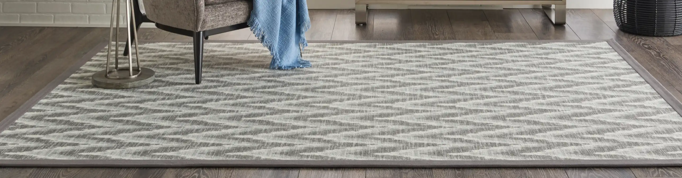 Area Rug in living area with wood look flooring and armchair